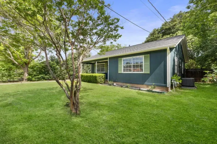 Charming exterior front with lush trees and neatly trimmed grass, enhancing the home’s curb appeal. The well-maintained landscaping creates a welcoming and serene atmosphere, offering a perfect blend of natural beauty and order. A peaceful setting th