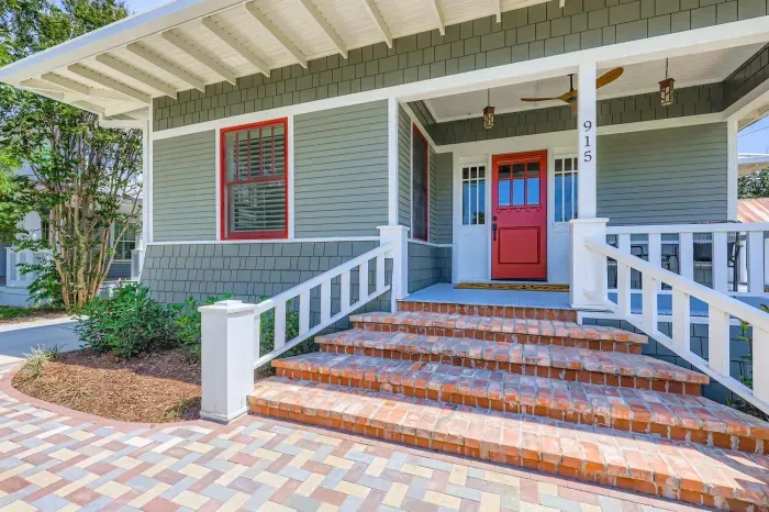 Charming front porch with red door – a welcoming touch.