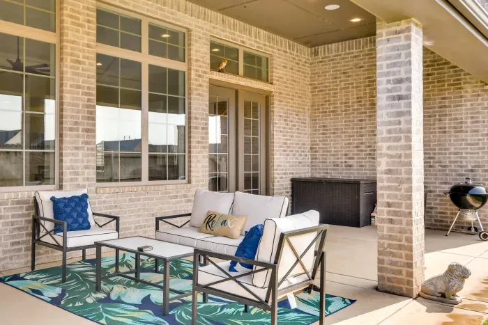 Covered patio with outdoor lounge seating and TV.