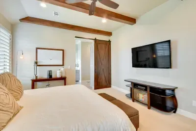 Bright primary bedroom with king bed and ceiling fan.