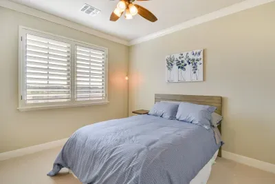 Peaceful bedroom with soft linens and warm tones.