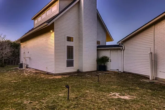 Spacious front yard with beautiful greenery and inviting entry.