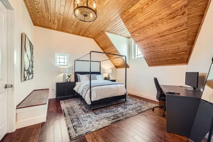 A serene and spacious bedroom featuring a cozy four-poster bed, natural textures, and soft, earthy tones.