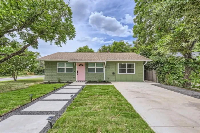 Charming front exterior with private driveway, shaded trees, and welcoming entryway