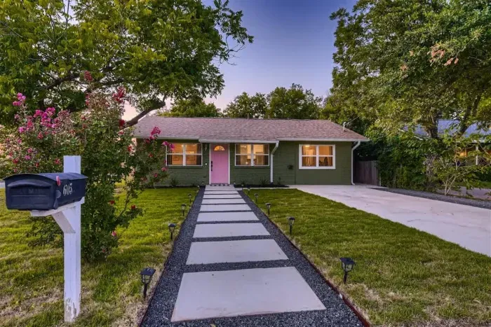 1. Beautiful front of the house, surrounded by lush trees and vibrant flowers, enhancing its curb appeal. The thoughtfully landscaped garden adds color and tranquility, creating a welcoming and serene atmosphere.