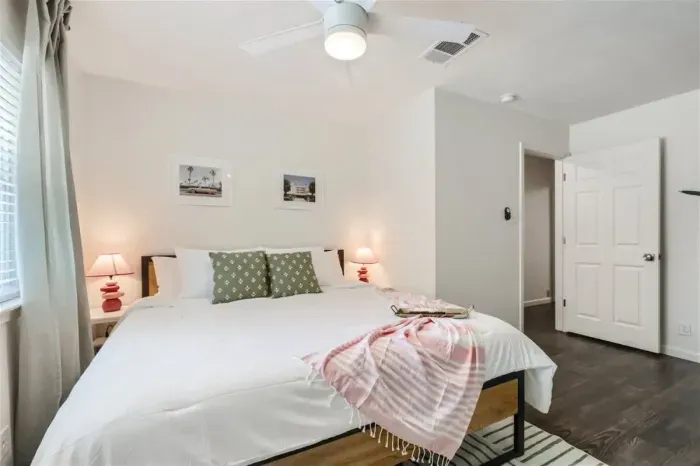 Bright and airy bedroom with large windows and blackout curtains for ultimate comfort.