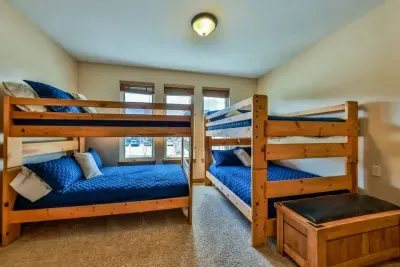 Cozy bedroom featuring two bunk beds, providing ample sleeping space for multiple occupants. This setup is perfect for families or groups, maximizing room functionality without sacrificing comfort. Ideal for creating a fun and efficient sleeping area