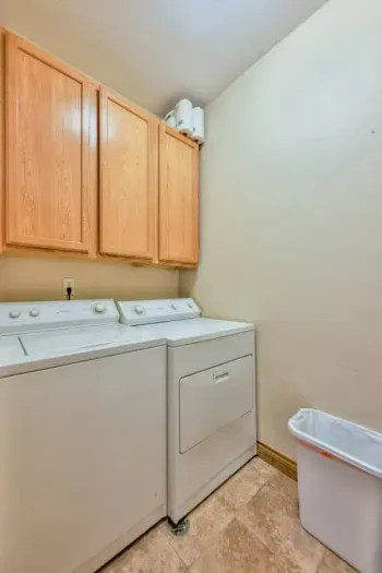 Bright and functional laundry space with folding counters, storage, and high-efficiency appliances.