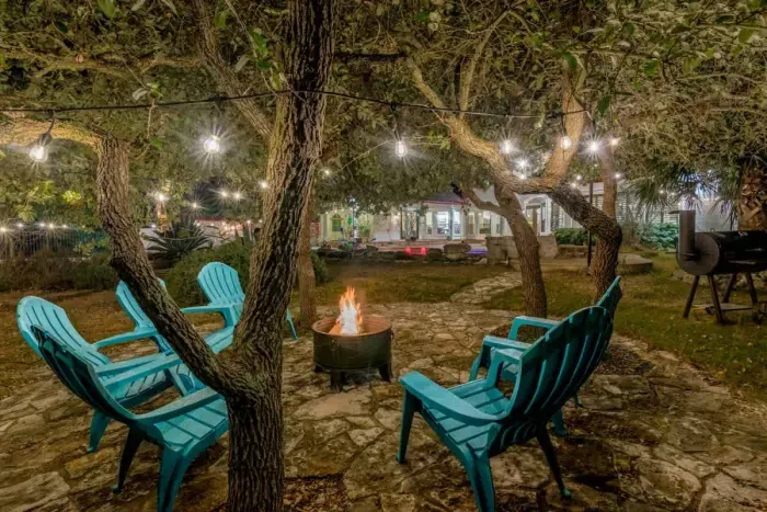 Cozy backyard retreat with string lights, a fire pit, and comfortable seating.