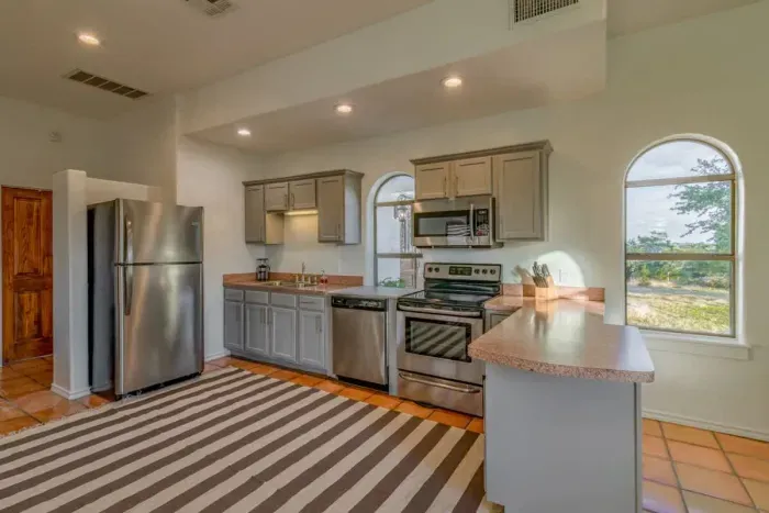 Bright and modern kitchen with stainless steel appliances, perfect for preparing a gourmet meal or quick snacks.