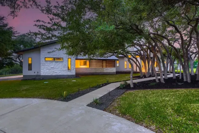 The exterior front sidewalk leads up to the entrance, framed by neatly manicured landscaping and a welcoming path. Its clean, smooth design provides easy access, adding to the home's inviting curb appeal.