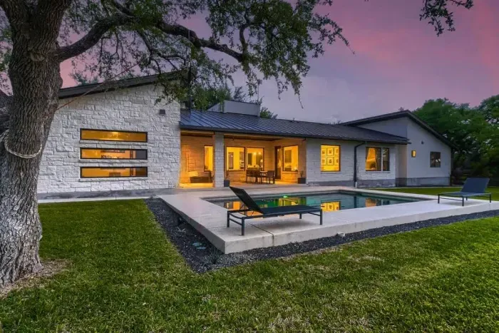 Discover contemporary luxury in this stunning Liberty Hill home. Featuring sleek stonework, an open-concept layout, and expansive windows, it offers elegance and comfort. The private backyard oasis boasts a sparkling pool and covered patio, perfect f