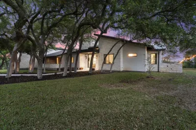 Charming exterior with shaded entry and Hill Country character.
