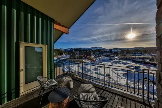 Covered balcony seating with winter mountain scenery.