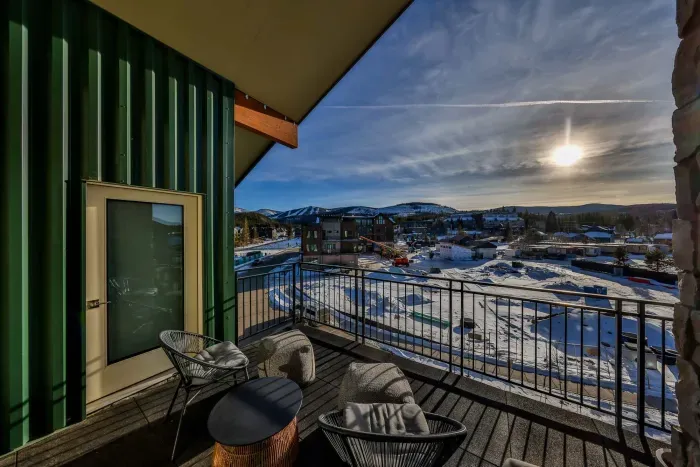 Covered balcony seating with winter mountain scenery.