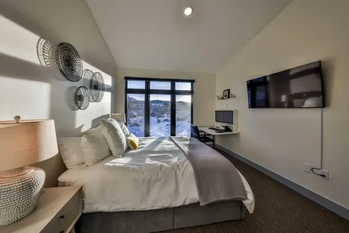 Bedroom with mountain views and floating desk workspace for remote work.