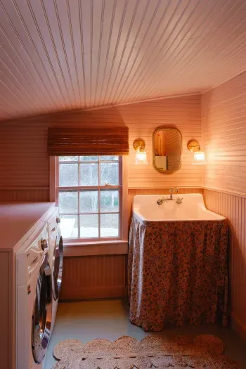 Vintage-style bathroom with sink, washer and dryer, and warm lighting