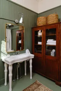 Classic bathroom with pedestal sink, storage cabinet, and vintage finishes.