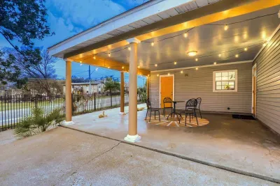 Covered front porch with café seating and string lights for relaxed outdoor evenings