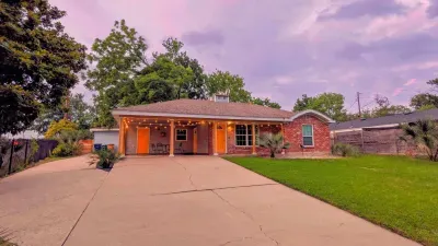 Front view of the home with inviting porch lights and lush landscaping.