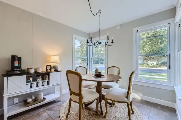 Bright and airy dining area with large windows and cozy seating for memorable meals.