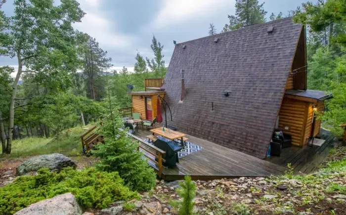 Deck equipped with outdoor seating, set in a serene environment. This tranquil space is perfect for entertaining or enjoying peaceful moments surrounded by nature. Ideal for those who love outdoor dining and relaxation.