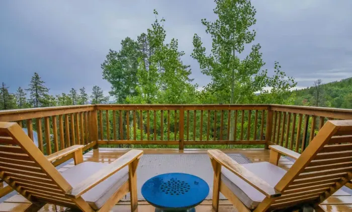 Expansive upper balcony offering breathtaking forest and sunset views. This serene space provides the perfect backdrop for relaxation, allowing you to unwind while soaking in the beauty of nature.