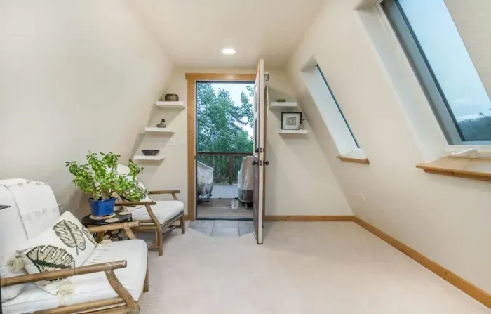 Inviting upstairs loft with direct access to a balcony, offering a seamless blend of indoor and outdoor living. This space provides a cozy retreat with fresh air and scenic views, perfect for relaxation or entertaining. Ideal for those who appreciate