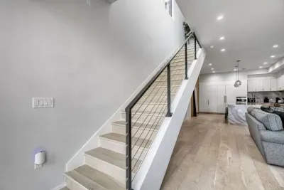 A sleek, modern staircase takes you to the other bedrooms and laundry space