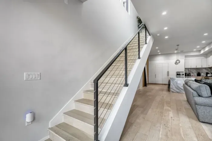 A sleek, modern staircase takes you to the other bedrooms and laundry space