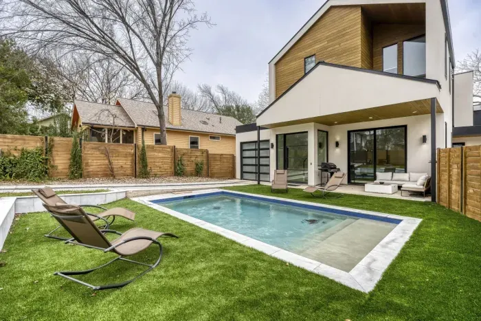 Private oasis with modern pool, covered patio, and stylish outdoor seating perfect for relaxing or entertaining.