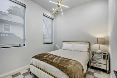Serene primary suite with plush bedding, natural light, and a calming modern design.