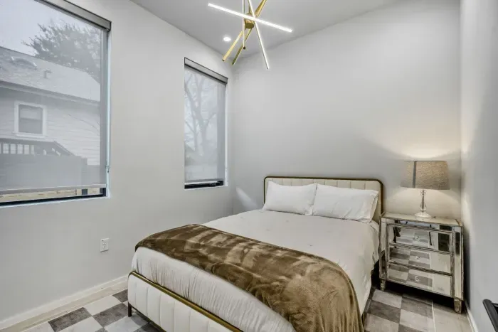 Serene primary suite with plush bedding, natural light, and a calming modern design.