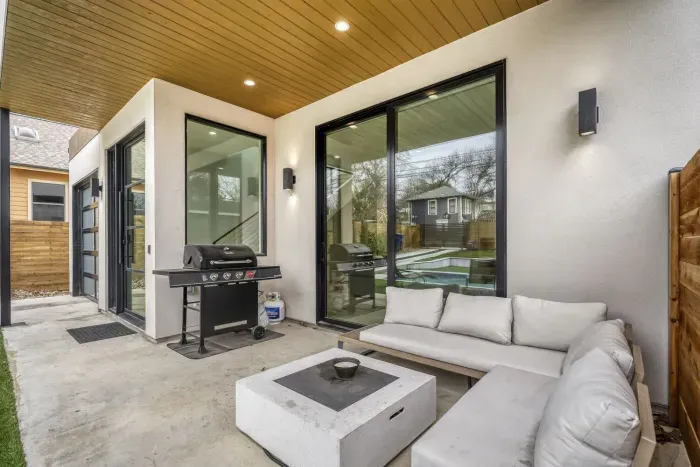 Modern covered patio, lounge chairs, and private pool area perfect for relaxing outdoors.