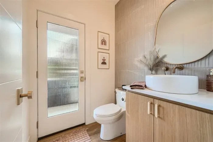 Convenient half bath on the main level, offering easy access to the patio and pool area. Perfect for guests, this bathroom ensures comfort and convenience while enjoying outdoor relaxation.
