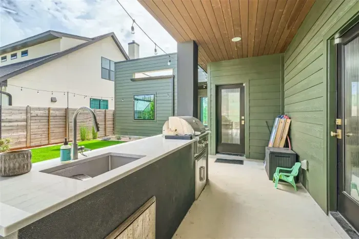 Relax and entertain on the outdoor patio, featuring a dedicated grilling area perfect for cooking and dining al fresco. Surrounded by comfortable seating, it's an ideal spot for enjoying meals and outdoor gatherings.