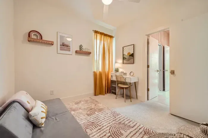 Bedroom 3 doubles as a versatile workspace, featuring a twin modular floor mattress/couch for flexible sleeping arrangements. The room also includes a dedicated workspace, ideal for remote work or study in a comfortable setting.