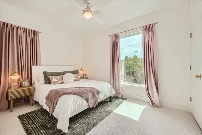 Bright and airy bedroom with large windows and blackout curtains for ultimate comfort.