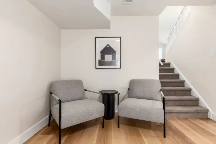 Cozy nook by the stairs with lounge seating for reading or unwinding.