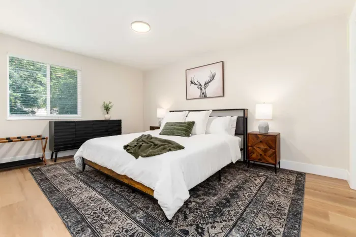 Spacious primary bedroom with plush bedding and peaceful atmosphere.