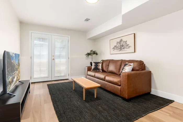 Bright and modern living room with comfy seating and smart TV.