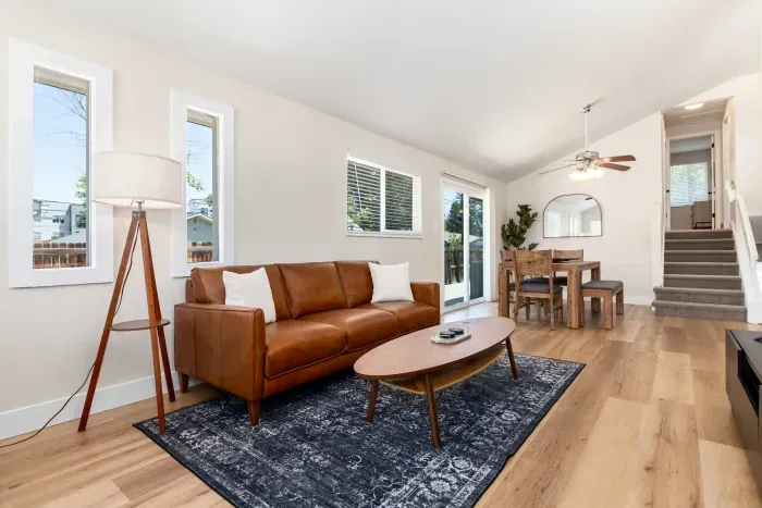 Contemporary living room with large windows and a sleek TV setup.