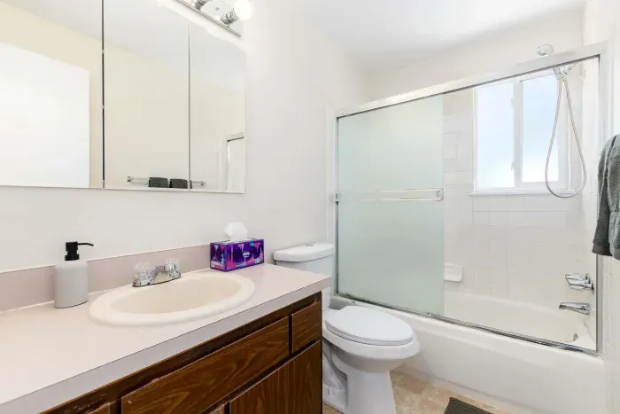 Spotless full bathroom with tub and shower combo.