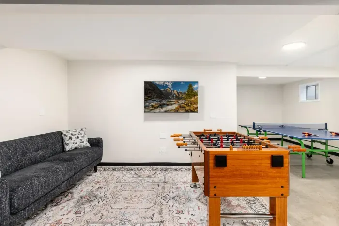 Spacious game room featuring foosball and ping-pong tables for all-ages fun.