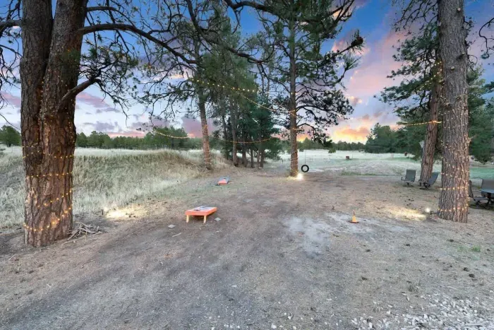 The outdoor game area at night.  Cornhole and horseshoes and a tire swing to boot!