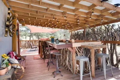 Discover the unique charm of the Bar Tree House, a whimsical retreat nestled among the trees. This elevated hideaway offers a cozy bar area for drinks and conversation, with stunning views and a peaceful ambiance, perfect for a relaxing escape in nat