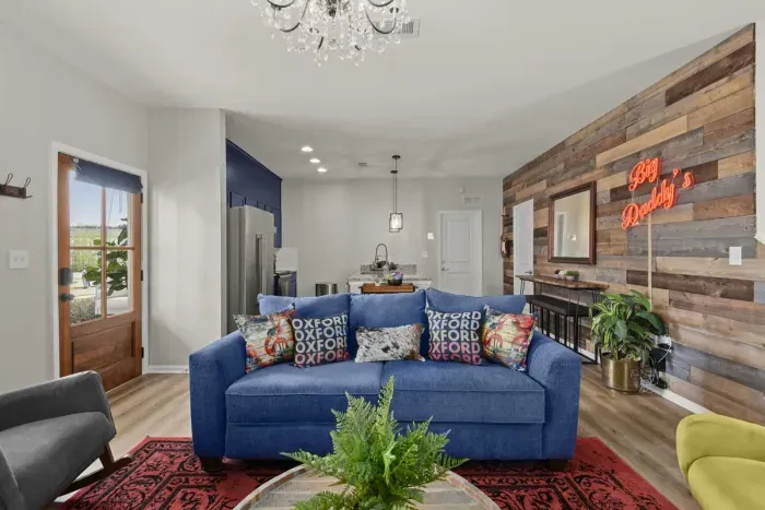 The hand crafted and stained pine door lead into the authentic living area with touches of natural wood, colorful plants and deep red Big Daddy’s sign.