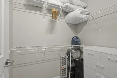 Huge closet with hangers, dresser, extra linens and baby gear.