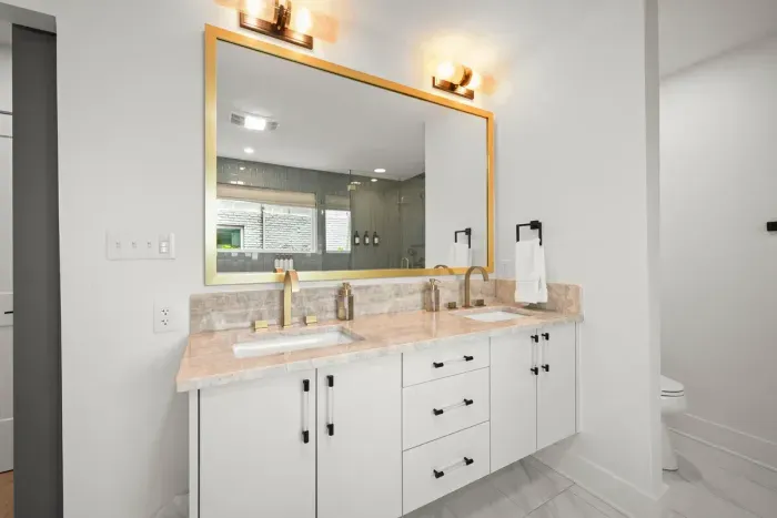 Elegant bathroom featuring a large vanity and modern amenities.