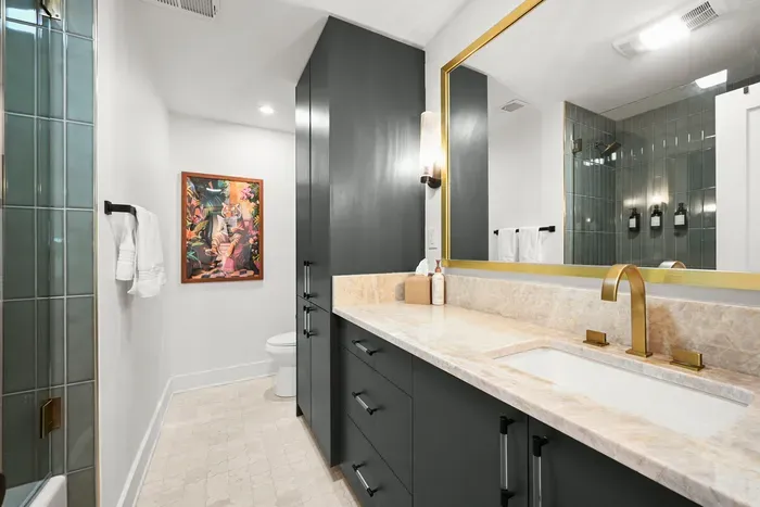 Spacious primary bathroom featuring a double vanity, modern finishes, and a walk-in shower.